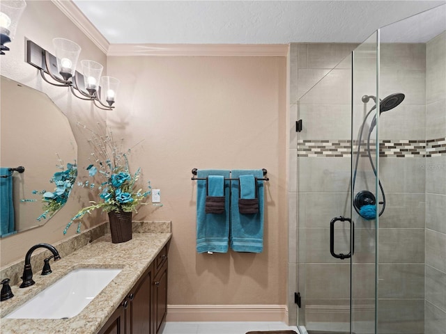 full bath with baseboards, a shower stall, vanity, and crown molding