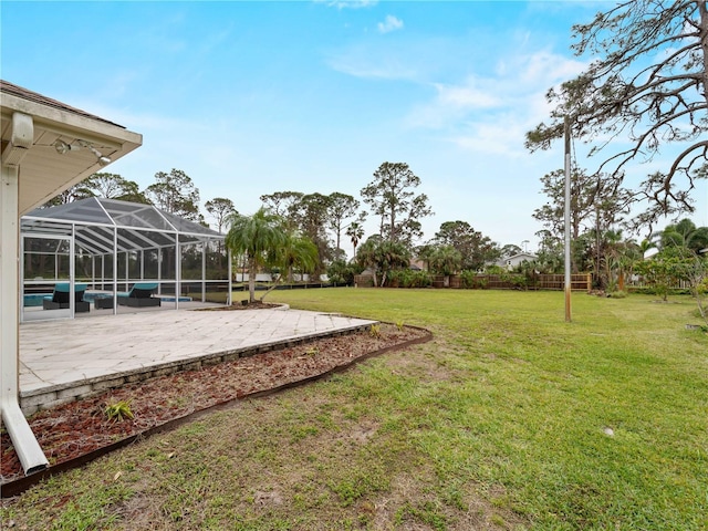 view of yard featuring glass enclosure and a patio area