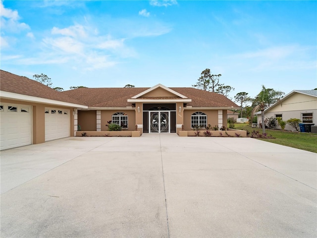 single story home featuring a garage, concrete driveway, and stucco siding