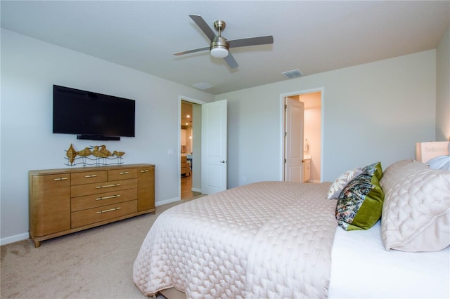 carpeted bedroom with ensuite bathroom and ceiling fan