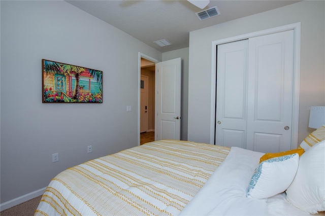 carpeted bedroom featuring ceiling fan and a closet