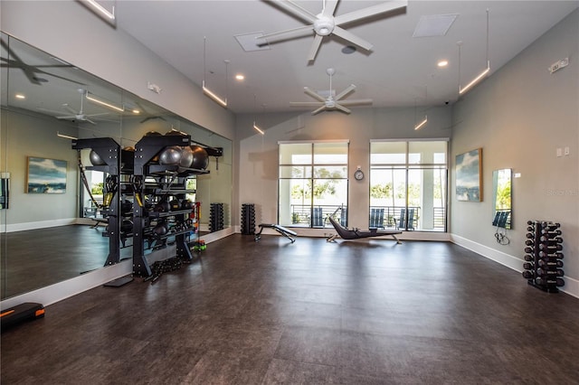 exercise room with a high ceiling and ceiling fan