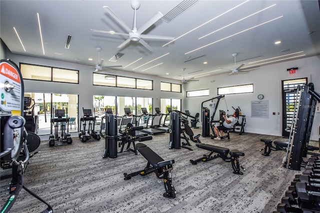 workout area featuring ceiling fan and a high ceiling