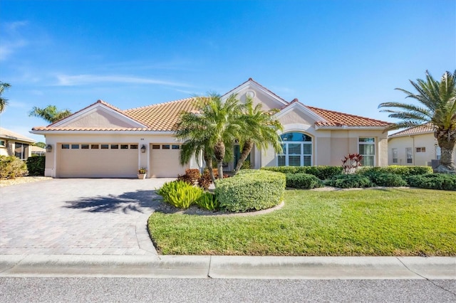 mediterranean / spanish-style home featuring a garage and a front lawn