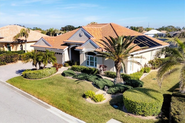 mediterranean / spanish-style home with a garage and a front lawn