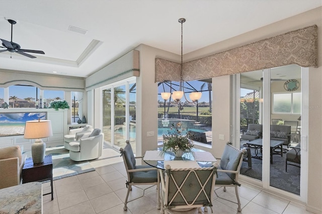 sunroom / solarium with a raised ceiling and ceiling fan with notable chandelier