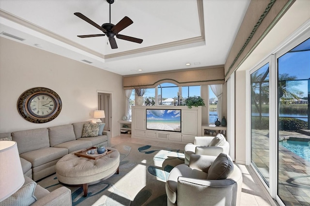 living room with a tray ceiling and ceiling fan