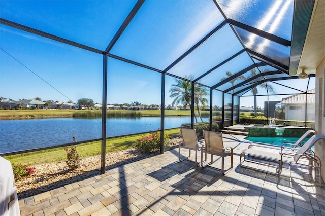 view of patio / terrace featuring a water view and glass enclosure