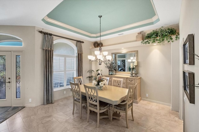 dining room featuring an inviting chandelier and a raised ceiling