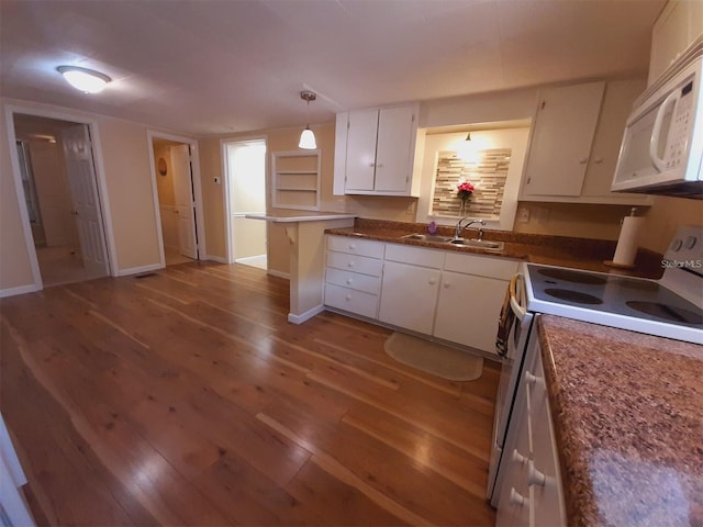 kitchen featuring pendant lighting, sink, white appliances, hardwood / wood-style flooring, and white cabinetry