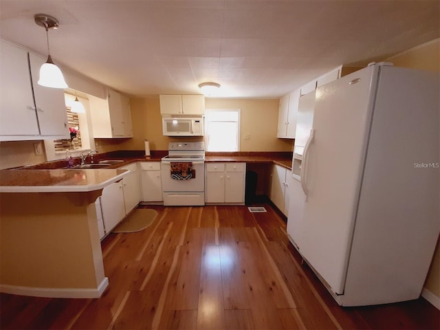 kitchen featuring hanging light fixtures, white cabinetry, white appliances, and kitchen peninsula