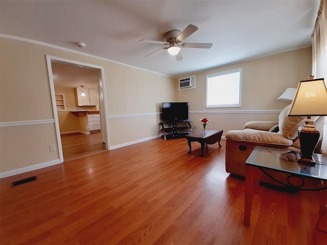 living room with ornamental molding, a wall mounted AC, ceiling fan, and light hardwood / wood-style floors