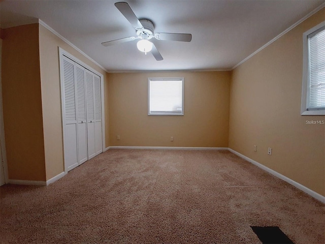 unfurnished bedroom featuring crown molding, light colored carpet, and a closet