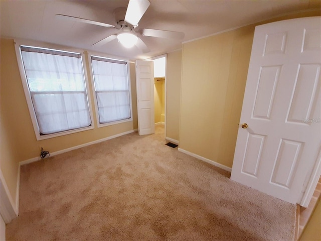 spare room with ceiling fan and light carpet