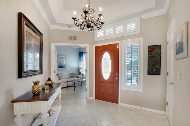 entryway with light tile patterned floors, ornamental molding, a raised ceiling, and visible vents