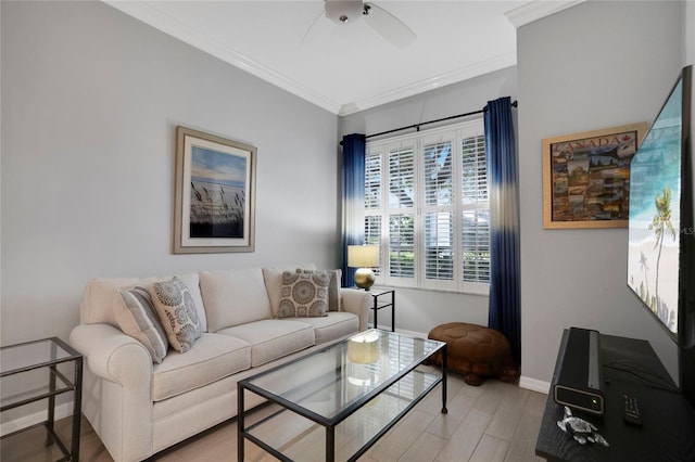 living area with light wood-type flooring, baseboards, ornamental molding, and a ceiling fan