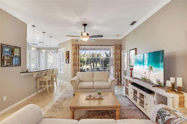 living area with light tile patterned flooring, visible vents, baseboards, a ceiling fan, and crown molding