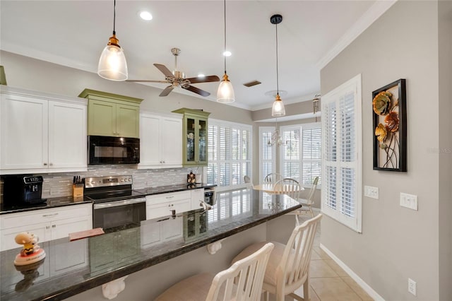 kitchen featuring black microwave, a breakfast bar, stainless steel range with electric stovetop, hanging light fixtures, and glass insert cabinets