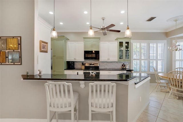 kitchen featuring stainless steel electric stove, hanging light fixtures, glass insert cabinets, black microwave, and a kitchen bar