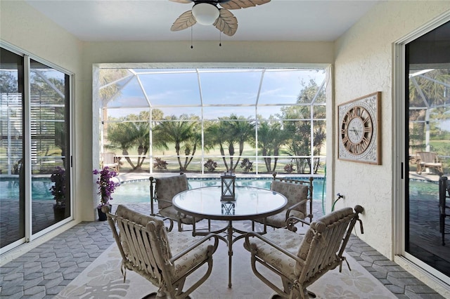 sunroom / solarium featuring a ceiling fan