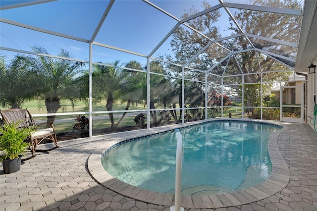 outdoor pool featuring glass enclosure and a patio area