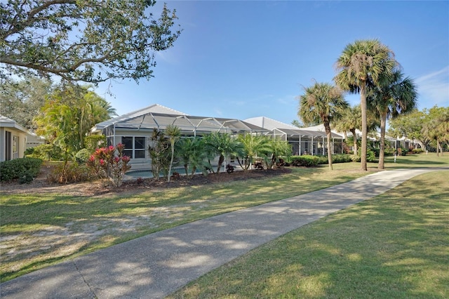 view of front facade featuring glass enclosure and a front lawn