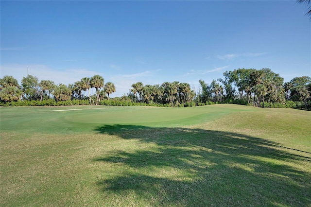 view of home's community featuring view of golf course and a yard