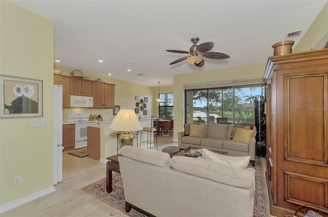 living room with light hardwood / wood-style flooring and ceiling fan