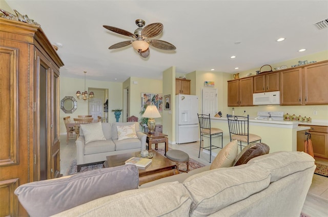 living room featuring ceiling fan with notable chandelier