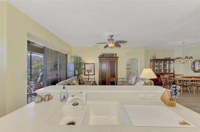 interior space with sink and ceiling fan with notable chandelier