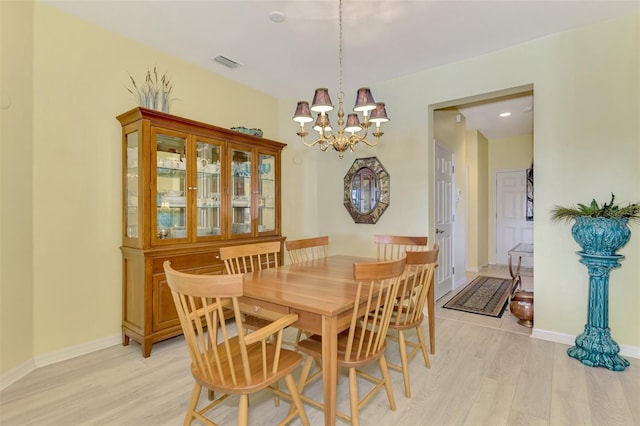 dining area with an inviting chandelier and light wood-type flooring