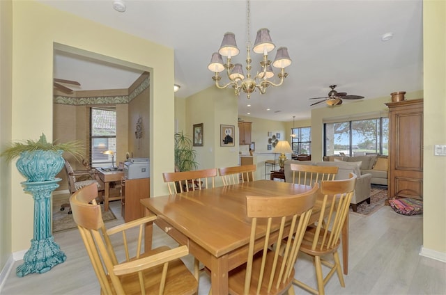 dining space featuring ceiling fan with notable chandelier and light hardwood / wood-style flooring