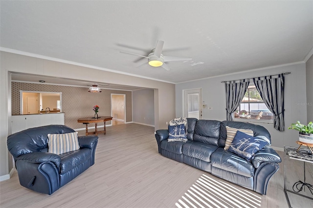 living room featuring ornamental molding, light hardwood / wood-style floors, and ceiling fan