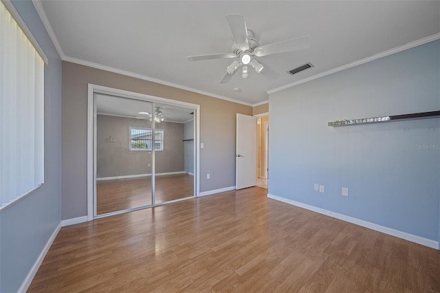 unfurnished bedroom with light hardwood / wood-style flooring, ornamental molding, a closet, and ceiling fan