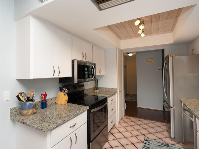 kitchen with white cabinets, a tray ceiling, stainless steel appliances, light stone countertops, and wooden ceiling