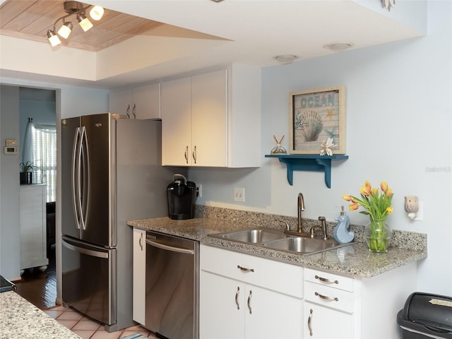 kitchen featuring sink, light tile patterned floors, appliances with stainless steel finishes, light stone countertops, and white cabinets