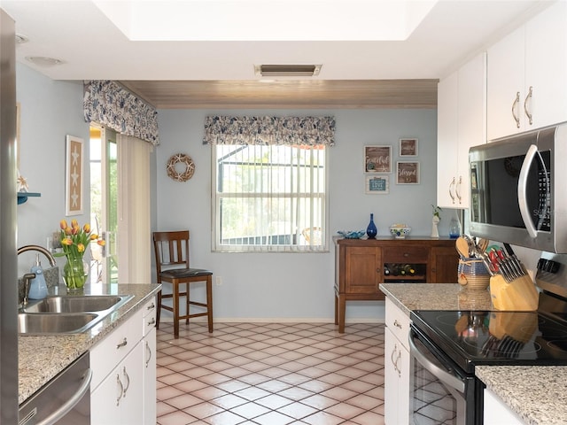 kitchen featuring white cabinetry, appliances with stainless steel finishes, sink, and light tile patterned flooring