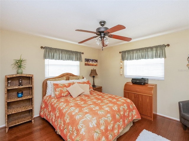 bedroom featuring multiple windows, dark hardwood / wood-style floors, and ceiling fan