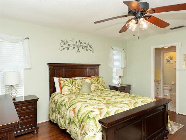 bedroom with ceiling fan, connected bathroom, and dark hardwood / wood-style floors