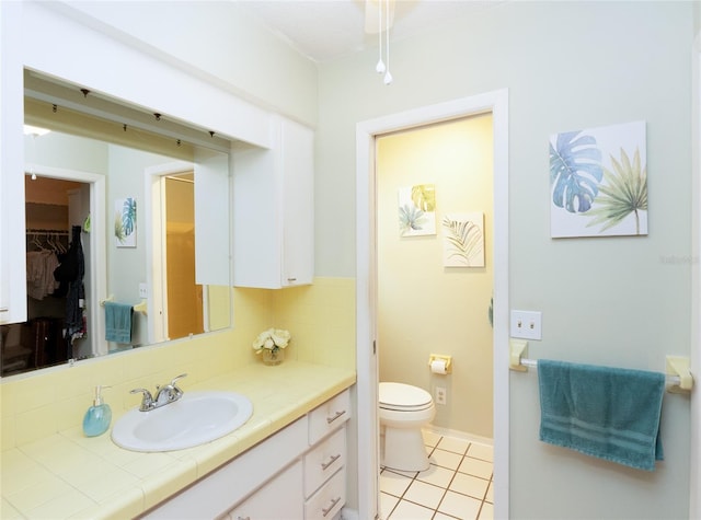 bathroom with vanity, backsplash, tile patterned floors, and toilet