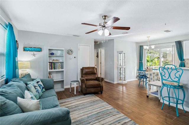 living room with wood-type flooring and ceiling fan with notable chandelier