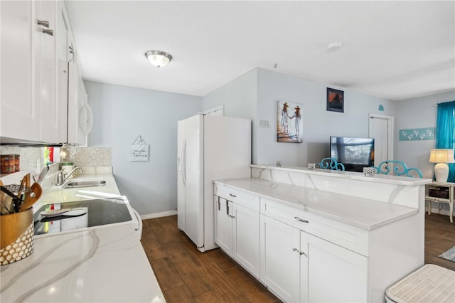 kitchen with white cabinetry, dark hardwood / wood-style floors, kitchen peninsula, white appliances, and light stone countertops