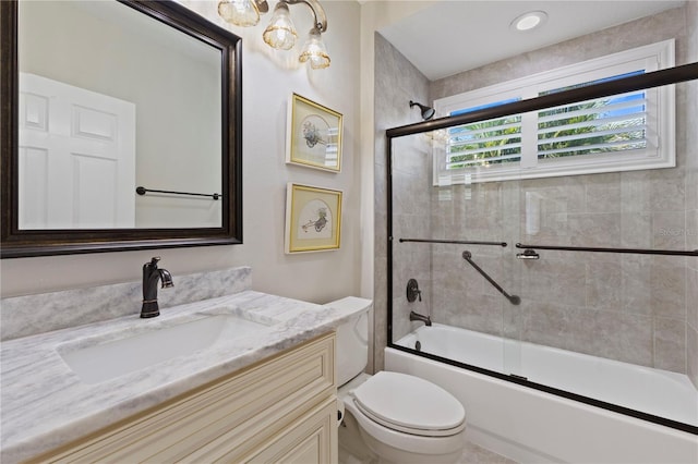 full bathroom featuring vanity, toilet, and combined bath / shower with glass door