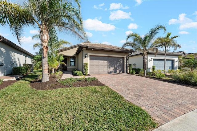 single story home featuring a garage and a front lawn