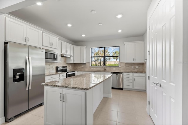 kitchen with sink, stainless steel appliances, a center island, and white cabinets