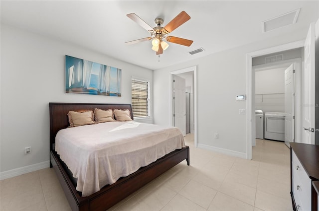 bedroom featuring connected bathroom, light tile patterned floors, washing machine and clothes dryer, and ceiling fan