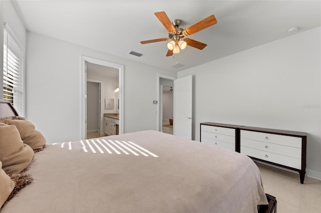 tiled bedroom with connected bathroom and ceiling fan