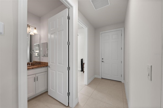 hallway featuring sink and light tile patterned floors