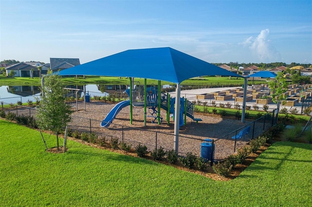 view of playground with a water view and a lawn