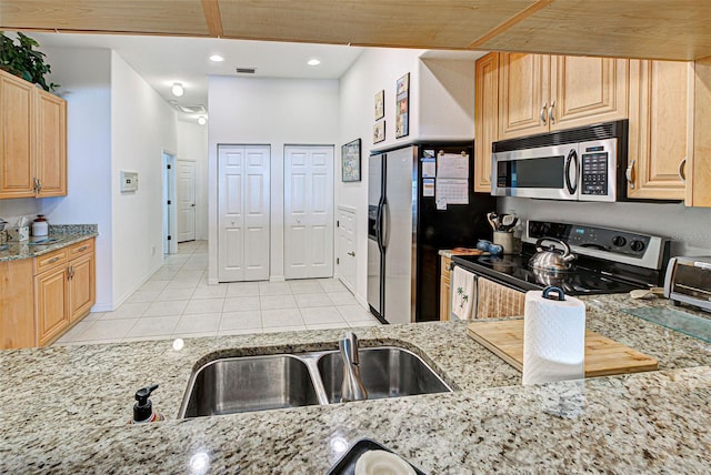 kitchen featuring sink, appliances with stainless steel finishes, light stone countertops, light tile patterned flooring, and light brown cabinetry